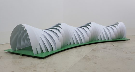 Curved structure made from bent paper strips on a green base